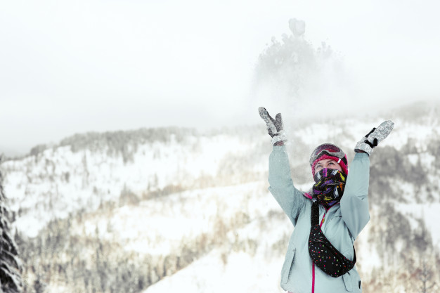 mujer-mira-como-cae-nieve-su-cara-mientras-posa-montana-invierno_8353-1063
